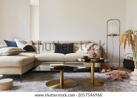 Creative living room interior composition with beige sofa, glass coffee table, carpet on the floor and glamorous accessories. Template.
