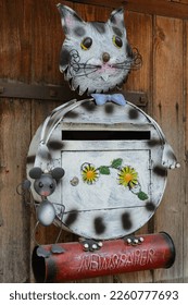 creative mailbox in design of cat and mouse with newspaper roll