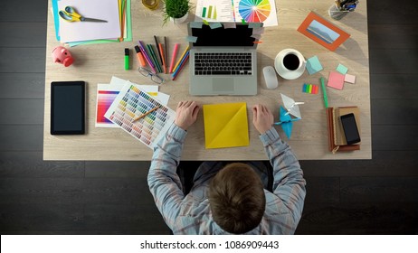 Creative Man Making Origami Cranes To Calm Down, Meditating On Ideas, Top View