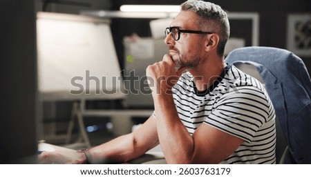 Creative, man and thinking by computer in office for project ideas and design trends research. Mature graphic designer, deadline or glasses with online inspiration and software brainstorming at night