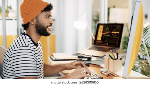 Creative, man and typing on computer at desk for social media insights, campaign performance and data analysis. Marketing employee, person and happy with digital app for engagement metrics in office