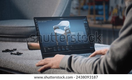 Creative man uses professional software for furniture design creation and 3D modeling working on laptop computer. Designer creates digital 3D model of stylish wooden chair, prepares carpentry project.