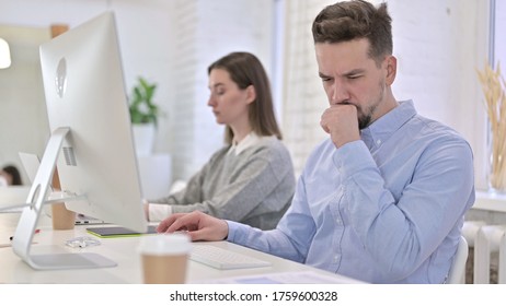 Creative Man Working On Desktop And Coughing In Office