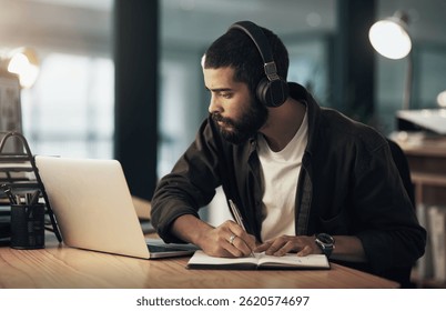 Creative, man and writing with notes, idea and video editor with night and headphones for project. Content creation, deadline and person with laptop, post production or design process with music