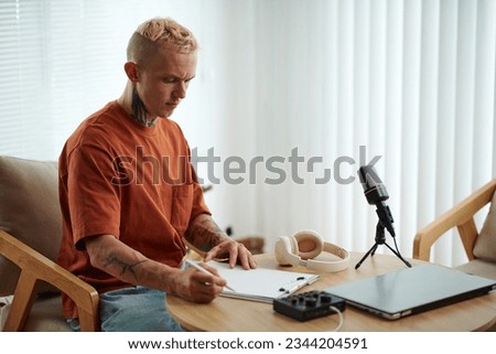 Creative man writing script before recording podcast in his studio