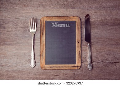 Creative menu background with chalkboard and silverware. View from above