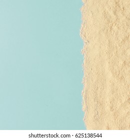 Creative Minimal Beach Concept. Summer Vacation Layout With Sand On Blue Background. Flat Lay.