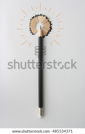 Creative minimal pencil and take concept as the lead of a pencil tip  Shavings breaking away transforming into a  light bulb shape.