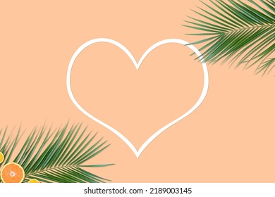 Creative Minimalistic Summer Background Of Palm Leaves With Citrus Fruit Slices And Heart Shaped Frame On Light Peach Background