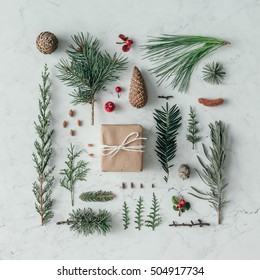 Creative natural layout made of winter things with christmas present on marble background. Flat lay.