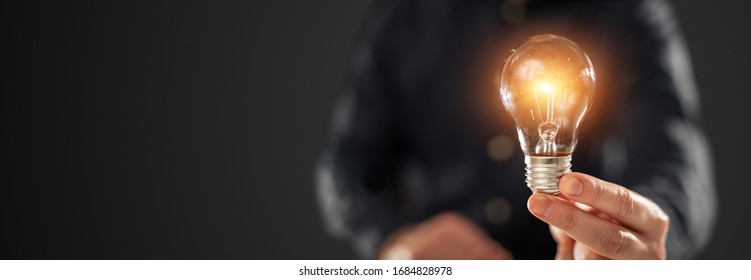 Creative new idea. Innovation, brainstorming, inspiration and solution concepts. The man is holding light bulb. Copy space background. - Shutterstock ID 1684828978