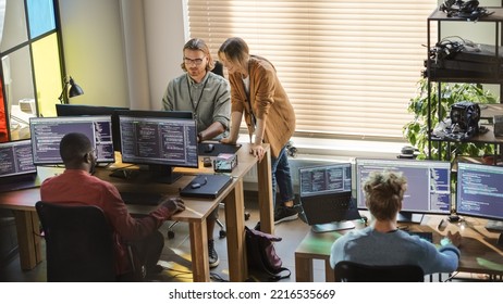 Creative Office: Diverse Colleagues Coding on Desktop Computers With Multiple Monitors. Female Project Manager Talks to Male Team Lead While Junior Developers Working on Mobile Application. - Shutterstock ID 2216535669