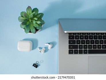 Creative Office Environment And Working Atmosphere For Working At Home. Coffee, Laptop, Phone And Headphones On Pastel Blue Desk Background.