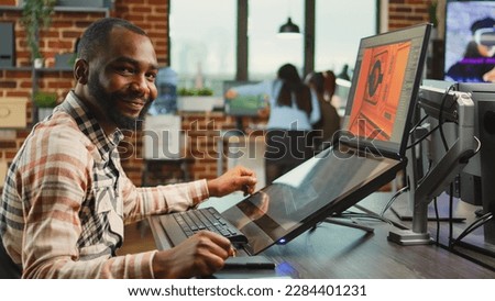 Creative office worker sitting at computer and creating digital art in agency studio, using multiple monitors and cad software. Professional graphic designer working on develoment project.