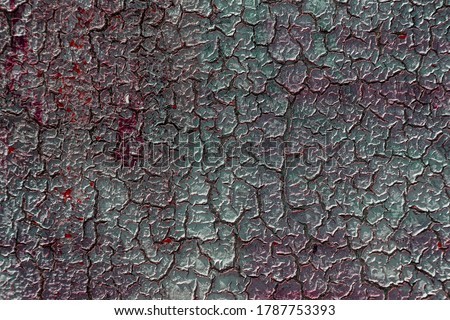 Creative old abstract background of large cracks of old weathered paint on the wall. Old paint weathered and cracked on the wall of the village house