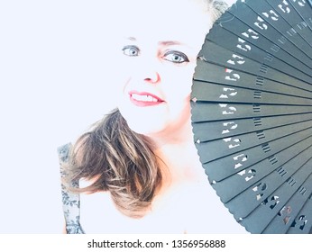 Creative Overexposed Portrait Of A Woman With Gray Eyes With A Spanish Fan