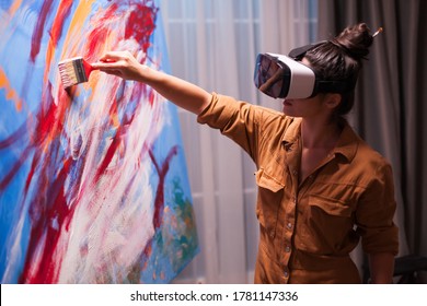 Creative painter with vr headset painting on canvas in art studio. Modern artwork paint on canvas, creative, contemporary and successful fine art artist drawing masterpiece