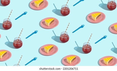 Creative Party Scene With Yellow Cake On Pink Plate And A Glass Of Red Cocktail On Sunny Day. Minimal Pattern Concept On Blue Background.