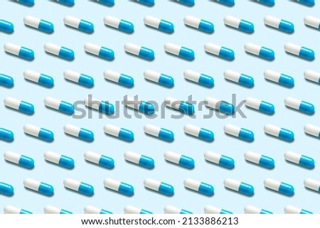Creative pattern with blue pills on bright background. Minimal pharmacy concept.