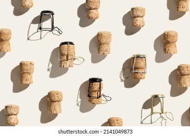 Creative pattern with champagne cork on beige background with hard light and shadows at sunlight. Minimal summer layout with bottle cap from sparkling wine and metal wire muselet, top view, flat lay