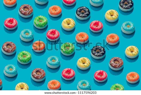 パステル青の背景にカラフルなドーナツのクリエイティブパターン 最小限の食べ物のコンセプト アイソメ の写真素材 今すぐ編集