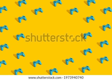 Creative pattern made with blue mint game joypad on yellow background. Minimal retro layout with copy space. 3d render.