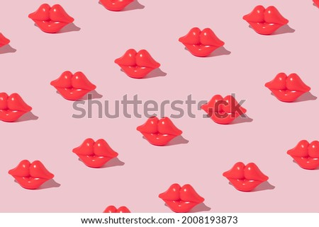 Creative pattern made with bright red lips figurine on pastel pink background. 80s or 90s romantic retro style aesthetic idea. Valentines day concept with kisses.