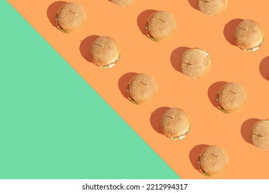 Creative pattern made of burgers on boldorange and green background. Street food and fast foodconcept. Minimal flat lay arrangement with copy space. - Shutterstock ID 2212994317