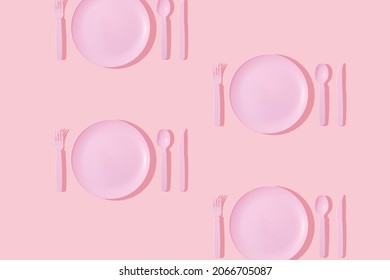 Creative pattern made with pastel pink plate, spoon, fork and knife on pastel pink background. Minimal surreal breakfast or food restaurant concept. Vintage aesthetic 80s or 90s fashion background.