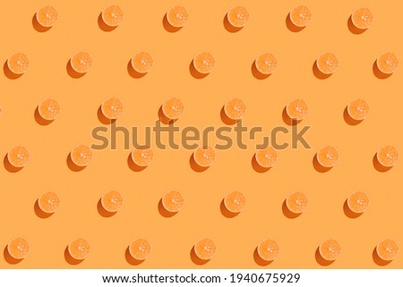 Creative pattern made with sliced fresh orange on bright background. Summer fruit concept. Minimal style. Sunlit flat lay. Top view