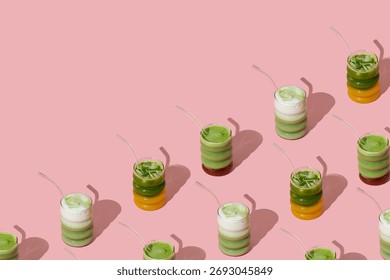 Creative pattern made with various colorful matcha drinks on pastel pink background with copy space. Minimal healthy matcha tea concept. Trendy drink idea.