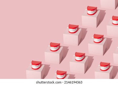 Creative pattern with teeth toy on pastel pink cube on pastel pink background. 80s or 90s retro fashion aesthetic concept. Minimal romantic smile idea.