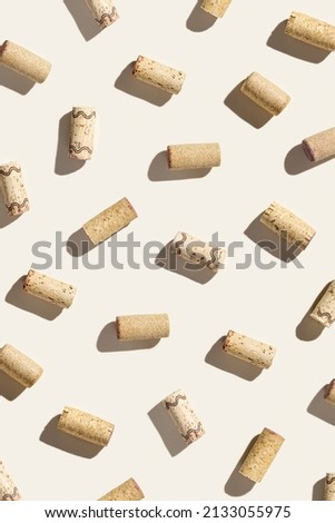 Creative pattern with wine corks on beige background with hard light and shadows at sunlight. Minimal style layout with bottle cap from red and white wine, top view, wine list backdrop
