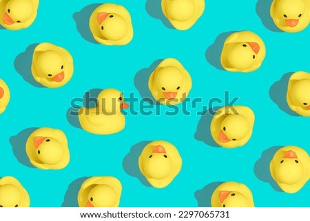 Creative pattern of yello cute rubber duckies on pastel blue background and summer sun with sharp shadows. Minimal concept of Summer Ducks. Creative art, Contemporary style, minimal esthetic
