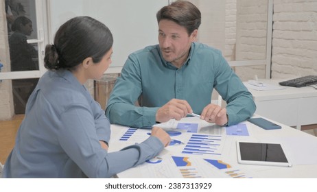 Creative People Talking while Doing Paperwork