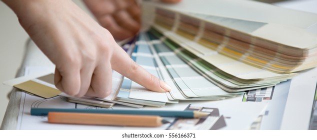 Creative people workplace. Close-up view of hands of young designer woman working with color palette at office desk. Interior shot. Horizontal photo banner for website header design - Powered by Shutterstock