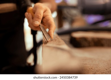 Creative person carving intricate designs into wood using chisel and hammer in carpentry shop. Woodworking expert in studio shaping wooden pieces with tools, close up shot - Powered by Shutterstock