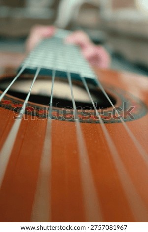 Creative perspective shot looking down the strings of a classical guitar from the bridge toward the neck.
