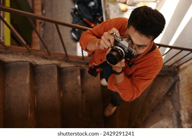 Creative photographer taking pictures on staircase of old abandoned building - Powered by Shutterstock