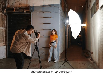 Creative photographer using studio light when working with model in old building - Powered by Shutterstock