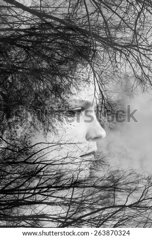 creative portrait of beautiful young woman made from double exposure effect using photo of trees and nature, black and white toned 