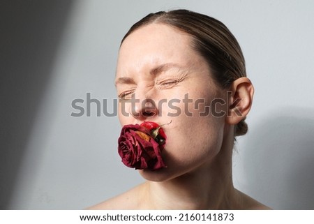 Creative portrait of woman with red lips and dry roses posing on whitewall. High quality photo.