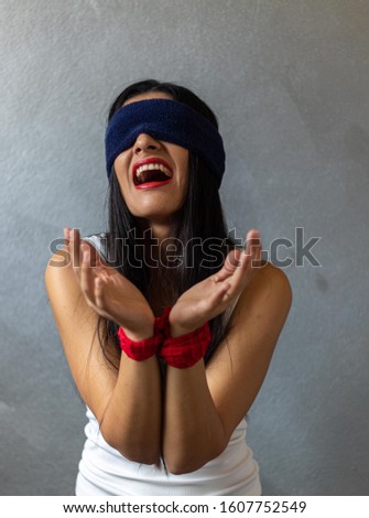 Creative portrait, woman tied with red cloth and blindfolded with blue cloth displaying the feeling of pain, prison, fear and prayer. Photo to show how you feel in depression. Creative portrait, art p