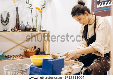 Creative process of creating pottery by mother and daughters. Female hands in a pottery workshop.