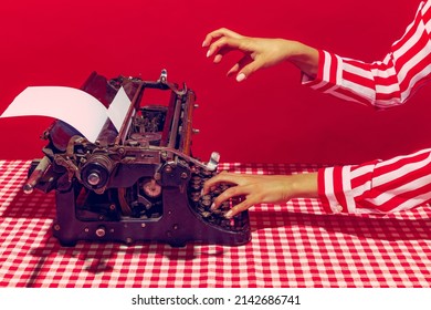 Creative process. Pop art photography. Female hand using retro typewriter isolated on bright red background. Vintage, retro 80s, 70s style. Complementary colors, Copy space for ad, text
