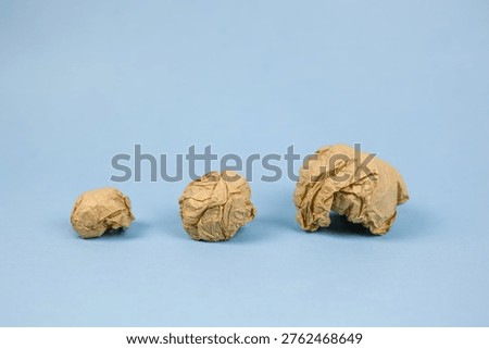 creative process seen through paper, kraft paper balls symbolize artistic experimentation stages, textural wrinkles and empty spaces emphasize decisionmaking in creative development phases