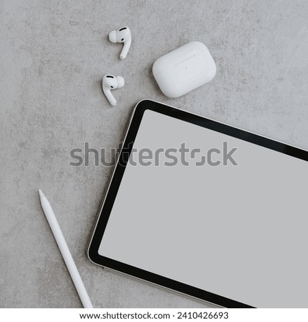Creative process. Tablet pad with blank screen, pencil, wireless earphones on concrete background. Flat lay, top view social media, web, online shop template with mockup copy space