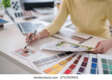 Creative professional hands explore vibrant color options selecting materials for new project at modern desk showcasing thoughtful design process