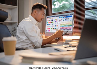 Creative professional using tablet and stylus while working on design project in modern office.