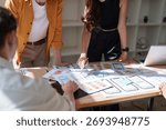 Creative professionals discussing wireframes and user experience designs for mobile application development. Modern office meeting